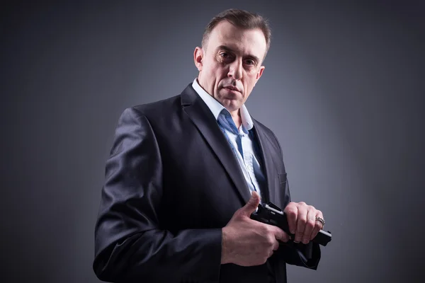 Man in business suit with a gun — Stock Photo, Image