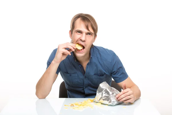 Hombre dispersa patatas fritas en la mesa —  Fotos de Stock