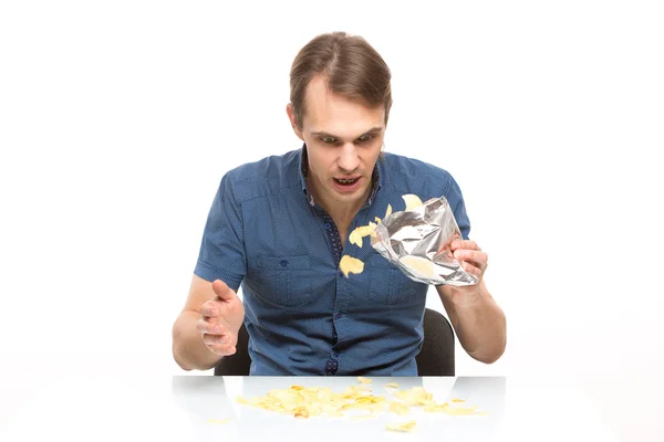 Homem espalhados batatas fritas na mesa — Fotografia de Stock