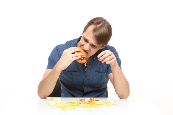 Man is not careful eating tasteless burger. Royalty Free Stock Photos