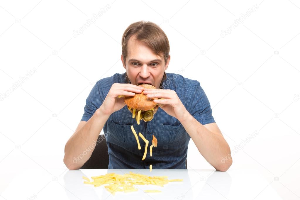 man is not careful eating tasteless burger.