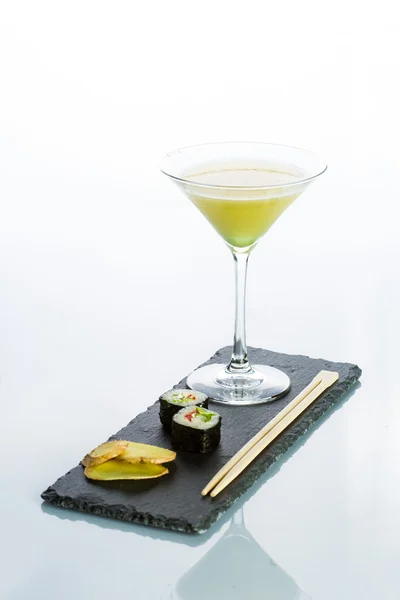 Coquetel amarelo com um conjunto de sushi no fundo branco — Fotografia de Stock