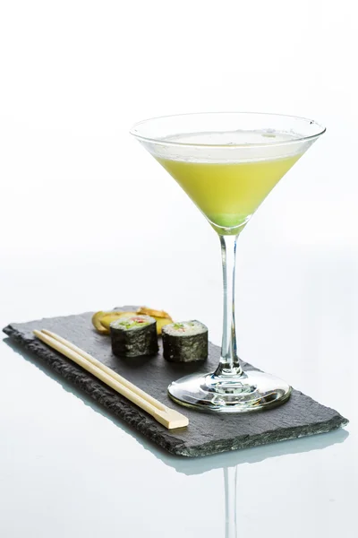 Gele cocktail met een set van sushi op witte achtergrond — Stockfoto