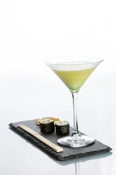 Gele cocktail met een set van sushi op witte achtergrond — Stockfoto