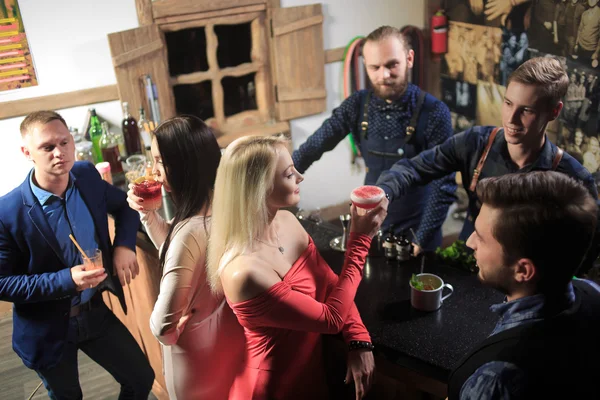 Barmann hinter Theke mit jungen Freunden an Cocktailbar — Stockfoto