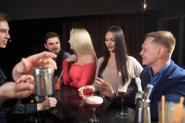 Barman atrás do balcão com jovens amigos no bar de coquetéis — Fotografia de Stock