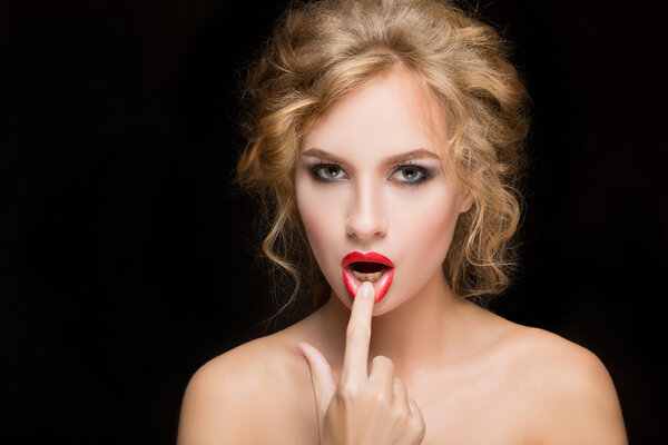 Portrait of beautiful girl with red lips. Red nails manicure. Studio shots. Black background. Beauty.