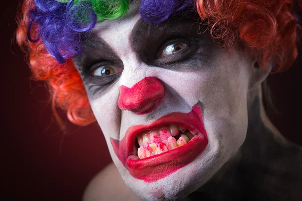 Bösen gruseligen Clown Porträt auf dunklem Hintergrund. Ausdrucksstarker Mann — Stockfoto