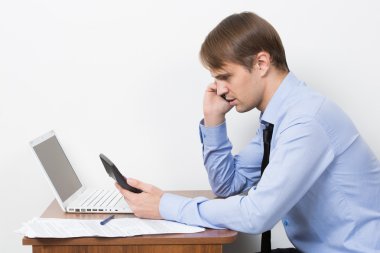 man with a calculator at his desk in the office