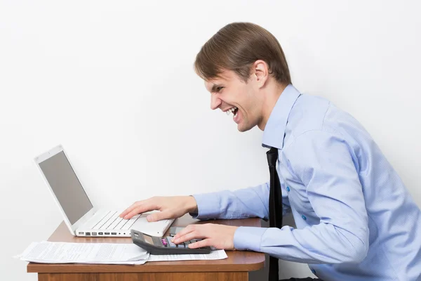 Man met een rekenmachine op zijn Bureau in het kantoor — Stockfoto