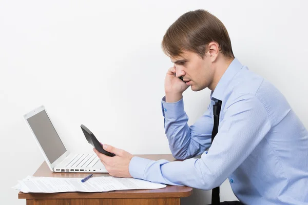 Man met een rekenmachine op zijn Bureau in het kantoor — Stockfoto