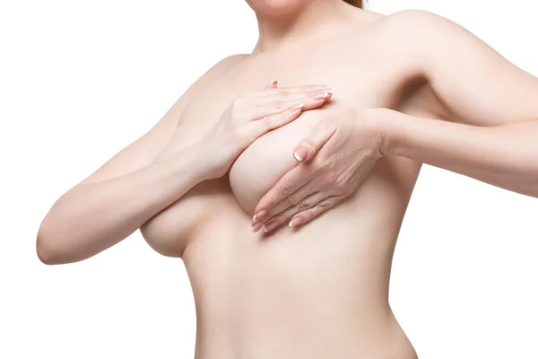 Изучаю грудь. Крупный план молодой женщины без рубашки, осматривающей свою грудь. Изолированный белый фон — стоковое фото