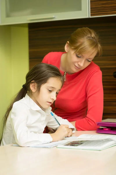 Hermosa chica de la escuela haciendo la tarea con la madre sexy en casa — Foto de Stock