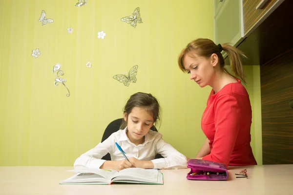 Hermosa chica de la escuela haciendo la tarea con la madre sexy en casa — Foto de Stock