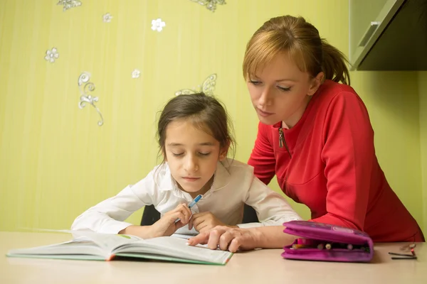 Hermosa chica de la escuela haciendo la tarea con la madre sexy en casa — Foto de Stock