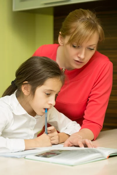 Mooie school meisje huiswerk met sexy moeder thuis — Stockfoto