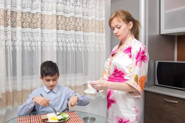 Junge glückliche schöne Mutter und ihr Kind essen gesundes Frühstück — Stockfoto