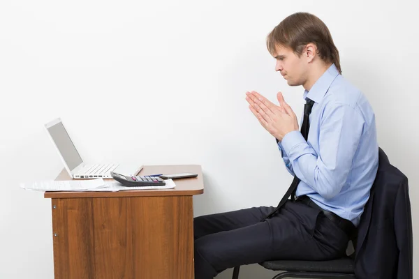Liikemies työskentelee valoisassa toimistossa, istuu pöydän ääressä, kannettavan tietokoneen avulla . — kuvapankkivalokuva