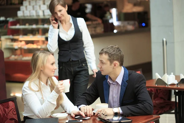 Uomini d'affari seduti per un computer portatile, discutendo plans.man e donna in caffè . — Foto Stock