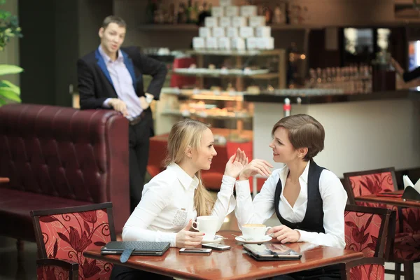 Dos novias del personal de la oficina. en la cafetería en un almuerzo de negocios. Mujer feliz en secreto — Foto de Stock