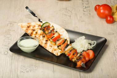 Şaşlık. kebap şiş, siyah dikdörtgen plaka. sos ve soğan