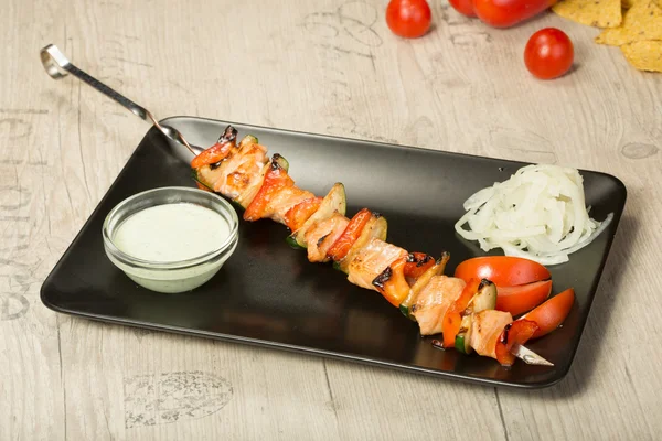 Shashlik. pincho de kebab, placa rectangular negra. salsa y cebolla — Foto de Stock