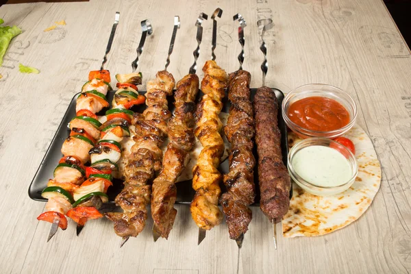 Conjunto shashlik. pincho de kebab, placa rectangular negra. salsa y cebolla — Foto de Stock