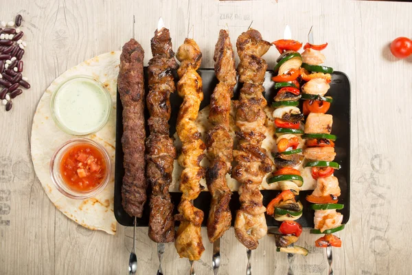 Conjunto shashlik. pincho de kebab, placa rectangular negra. salsa y cebolla — Foto de Stock