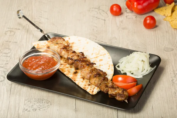 Sjasliek. kebab Spies, zwarte rechthoekige plaat. saus en uien — Stockfoto