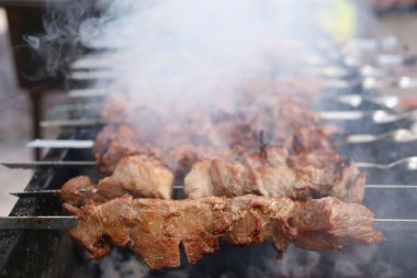 Grilling marinated shashlik on a grill. Shish kebab popular in Eastern, Central Europe and other places.