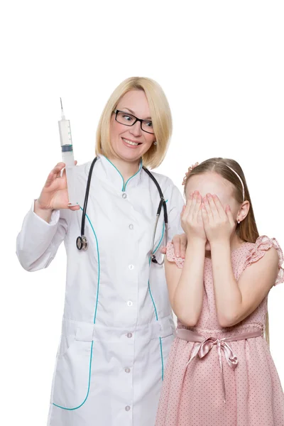 Doctor loco inyectando vacunas a un niño. jeringa enorme. Fondo blanco aislado — Foto de Stock