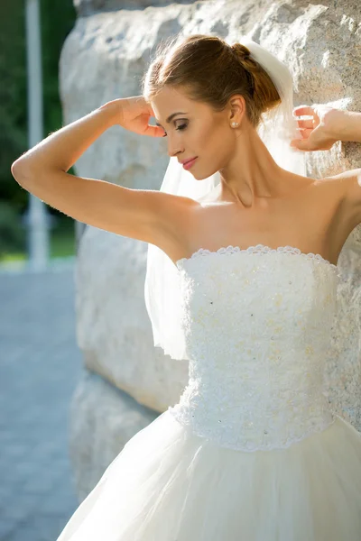 Retrato de novia hermosa en el parque. fondo muro de piedra —  Fotos de Stock