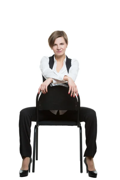 Woman sits astride a chair. sexy shows wrist. dominant position. Isolated white background — 图库照片