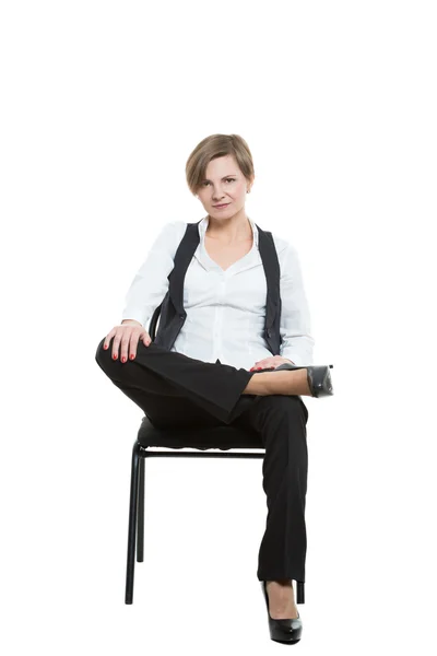 Femme est assise à côté d'une chaise. jambes croisées, bras fixe. manque. position dominante. Fond blanc isolé — Photo