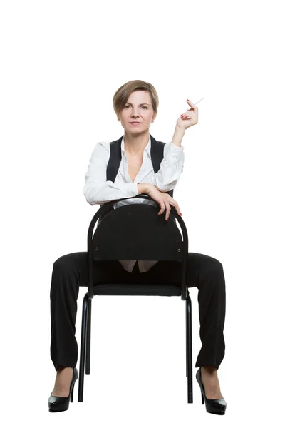 La mujer se sienta a horcajadas en una silla. sexy muestra la muñeca. posición dominante. Fondo blanco aislado. lenguaje corporal — Foto de Stock