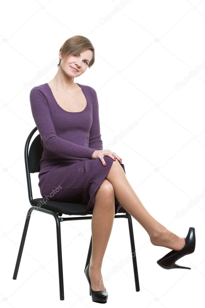 woman sits a chair. pose showing sexual desire. flirting. legs crossed, shoe drops. flexing. Isolated white background. body language