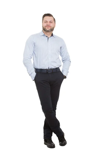 Homem adulto com barba. isolado em fundo branco. pernas cruzadas de pé, mãos nos bolsos. gesto de protecção . — Fotografia de Stock