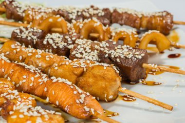 Grilled juicy skewered shashlik on a plate, sesame