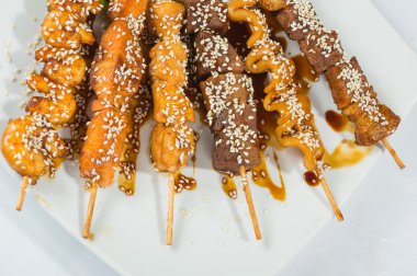 Grilled juicy skewered shashlik on a plate, sesame