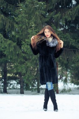 arka plan karlı ağaçların güzel gülümseyen kız. Kış portre. bir başlık ile kat