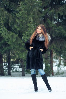 arka plan karlı ağaçların güzel gülümseyen kız. Kış portre. bir başlık ile kat