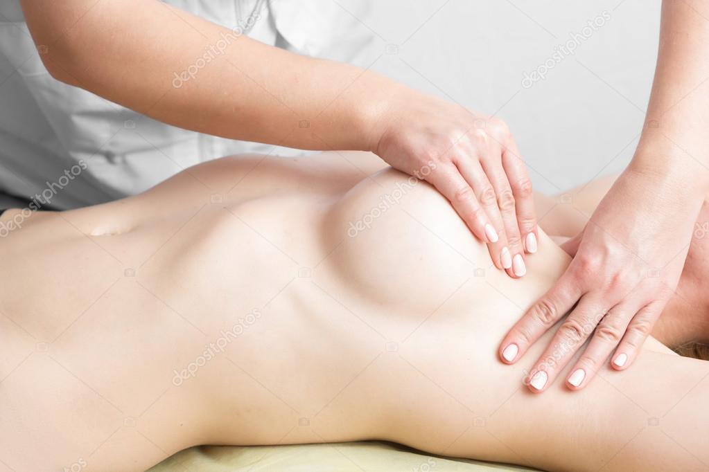 Beauty young woman recieving breast massage at spa. masseurs hands on the womans breast