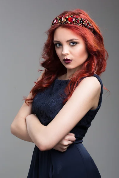 Modelo de moda bonita ruiva posando em vestido de noite e no diadema sobre fundo escuro. gestos femininos de sedução. linguagem corporal. gesto de agressão — Fotografia de Stock