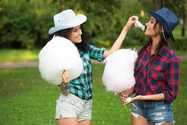 Meninas bonitas em chapéus de cowboy comer algodão doce — Fotografia de Stock