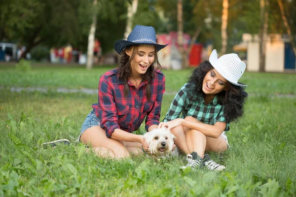 Deux filles marchant avec son chien. chapeau de cow-boy et chemise à carreaux — Photo