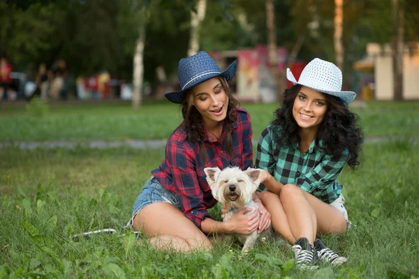 Due ragazze che camminano con il suo cane. cappello da cowboy e camicia a quadri — Foto Stock