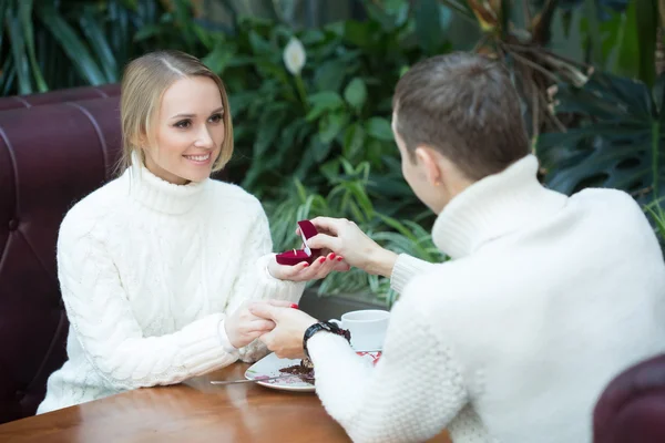 Joven proponiéndole matrimonio a novia ofreciéndole anillo de compromiso. sentado en un café — Foto de Stock