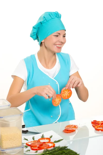 Vaření a jídlo koncept - usmívající se žena šéfkuchař, kuchař nebo baker, sekání zeleniny. Izolované na bílém pozadí — Stock fotografie