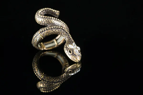 Ring with stones in the form of snake on black background — Stock Photo, Image