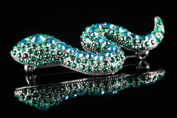 Brooch in the form of a snake. green stones. black background — Stock Photo, Image